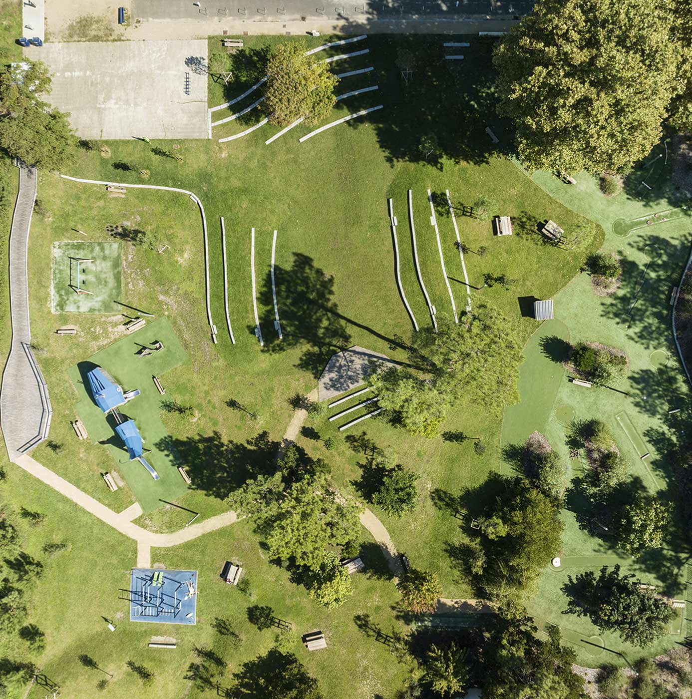 Luftaufnahme eines Parks mit Spielplatz, Trimm-Dich-Pfad, Minigolfanlage und gepflegten Grünflächen zwischen Bäumen
