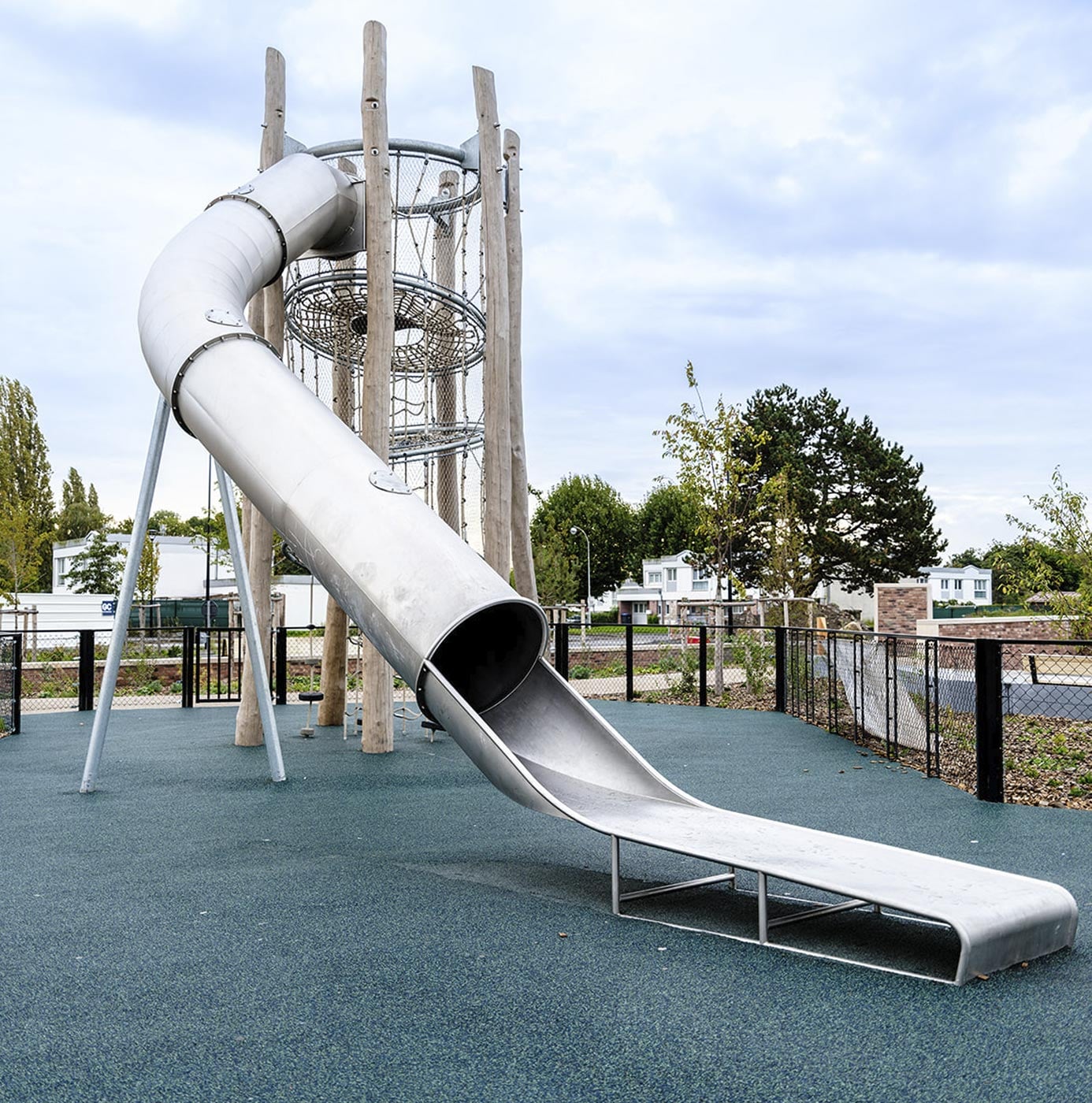 Edelstahl-Röhrenrutsche mit Kletterturm auf Fallschutzboden im neu gestalteten Spielplatz